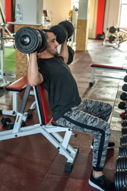 Güçlü genç sporcu spor giyer spor salonunda egzersiz yapar. vücut ağırlığı geliştirme kavramı