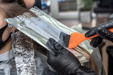 Güzel genç bir kız, arkadaşlarının tavsiyesiyle kuaföre geldi. Saç boyama için. Salgın sırasında kabinde bir kız olduğu düşüncesi