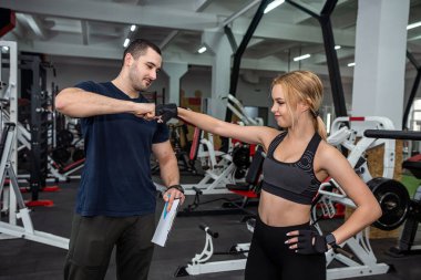 Formda bayan müşteri spor salonunda ağır dambıllarla kişisel erkek eğitmenle çalışıyor. sağlıklı yaşam tarzı için spor