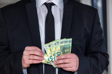 Avro banknotlarını takım elbisenin cebinde saklayan bir iş adamı. Yolsuzluk veya yasadışı iş kavramı.