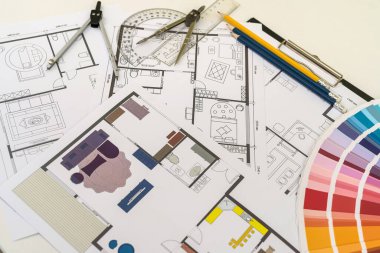 Ofis masasında yeni projenin planları ve renk örnekleyici çizim aletleriyle çalışıyor. mimarlık projesi