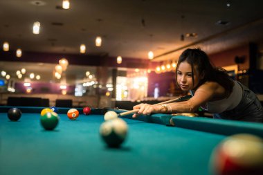 Bilardo oynayan ve bilardo oynayan kadın oyuncu.