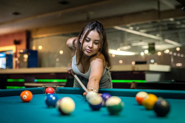 pretty lady take to easy shoot to win in billiards game. pleasantly spent free time