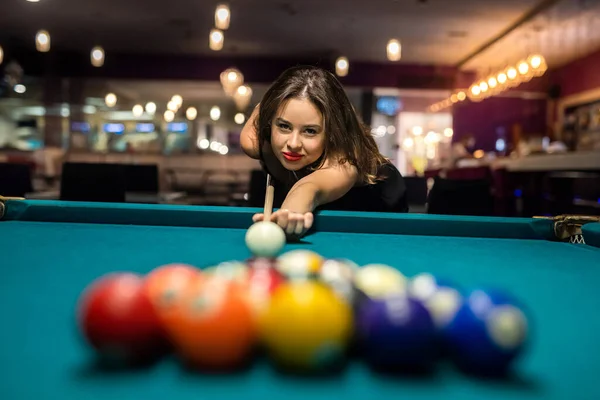 pretty caucasian woman playing snooker at pub. game concept