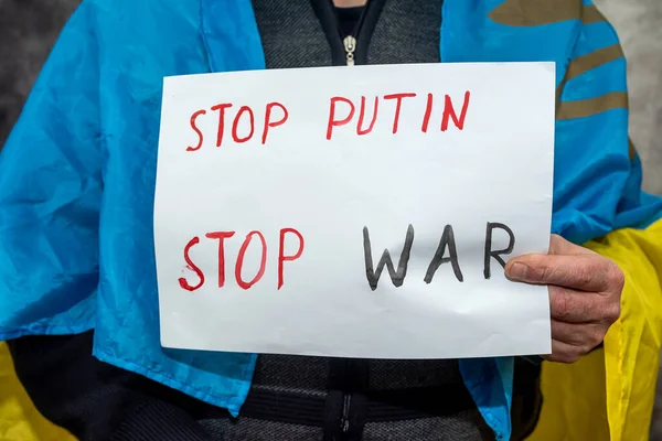 Erkek eller, üzerinde yazı olan afiş taşıyor. Putin 'i durdurun. Rusya 'dan saldırgana ve uluslararası teorisyene 