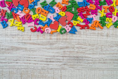 İlköğretim için çok renkli küçük tahta harfler yığını. İngiliz harfleri ahşap masada düzensiz bir sırayla.