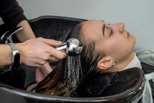 in beauty salons, qualified masters wash their heads before hair treatments. Hair washing concept. The concept of beauty salons and their service