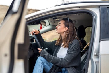 Yazın arabanın yanında poz veren baştan çıkarıcı kadın şehrin dışında özgürlüğün tadını çıkarıyor.