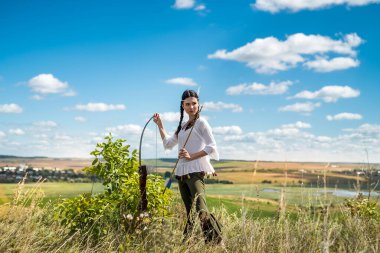 Güzel bir Hintli kadının portresi çevreyi çevreleyen bir doğada poz verir. Yerli Amerikan kadın avcısı.