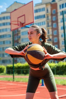 Sportif figürlü atletik seksi kız sahada basketbol oynuyor. Basketbol oyunu konsepti