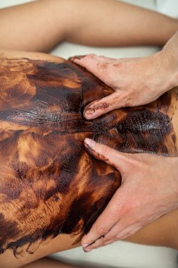 Bayan müşteri spa salonunda çikolata terapisiyle masaj yapmaktan hoşlanıyor. Rahatlayın ve sağlık yaşam tarzı