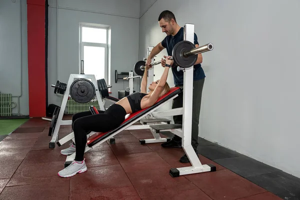 Fitness male trainer with his client working exercising at the gym. Energy concept, training