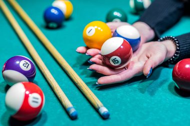 Bilardo masasında bilardo topları var. Oyuncuların elleri ve sopalarıyla. Spor ve kumar kavramı.
