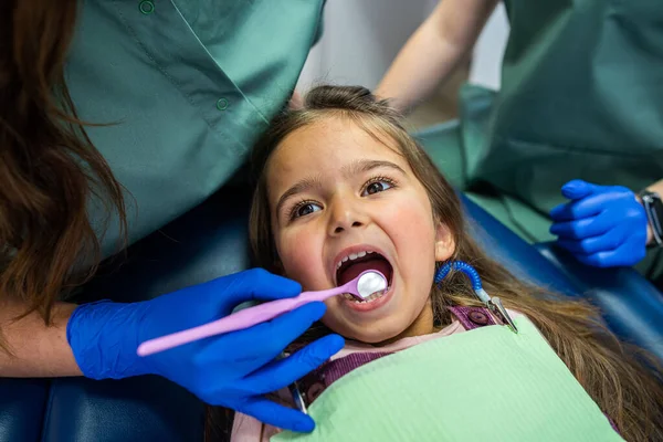 Κοριτσάκι Που Κάθεται Οδοντιατρική Καρέκλα Και Δύο Γυναίκες Οδοντίατροι Που — Φωτογραφία Αρχείου