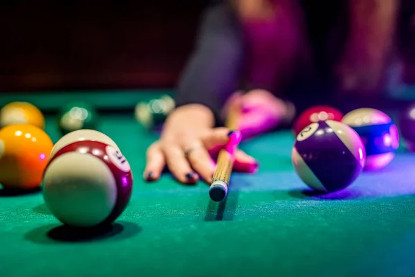 Billiard balls on the table and the player\'s hands are preparing to strike in the start mode. Indoor sports concept