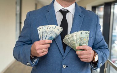 Takım elbiseli ve kravatlı, gelecek vaat eden yakışıklı bir adamda bol miktarda Polonyalı zloti bulunur. İş ve kâr kavramı