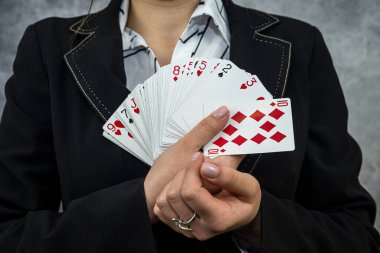 Takım elbiseli kadın kumarhanede kart oyunlarında kazanan kombinasyonu gösteriyor.. 