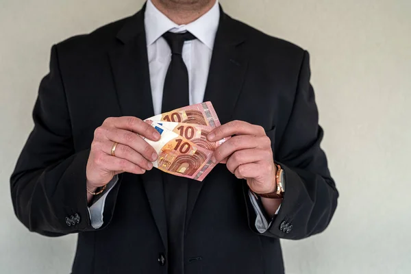 Business man wearing suit giving euro banknotes to subordinate office. concept of finance profits in a large company