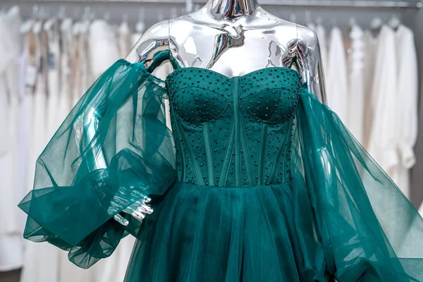 evening green female dresses on mannequin in modern clothing store, fashion concept