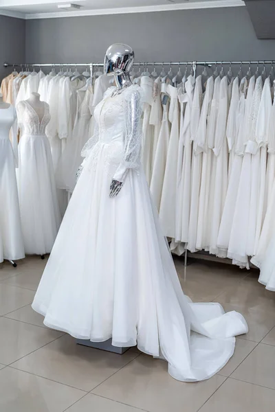 White wedding gowns on display at  modern bridal shop showroom