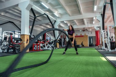 Genç bayan antrenör spor salonunda iple antrenman yapıyor. Spor sahası. 