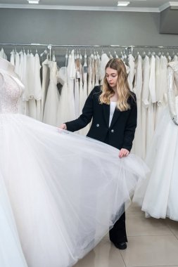 Genç bir kadın düğün butiğinde en iyi gelinliği seçiyor. En önemli düğün günü.