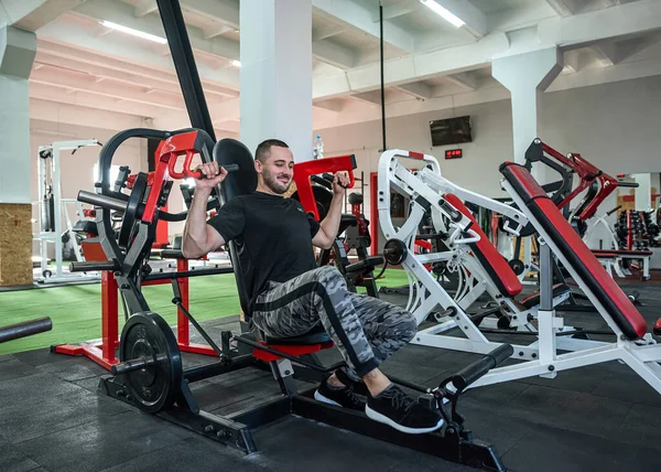 Güçlü genç sporcu spor giyer spor salonunda egzersiz yapar. vücut ağırlığı geliştirme kavramı