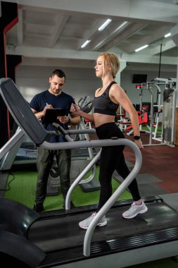 Mutlu, yorgun müşteri, gelecek vaat eden egzersizleri ve fiziki durumu için spor eğitmeni kocasına minnettar. Koçunun kocasına minnettar olan bir müşteri konsepti.