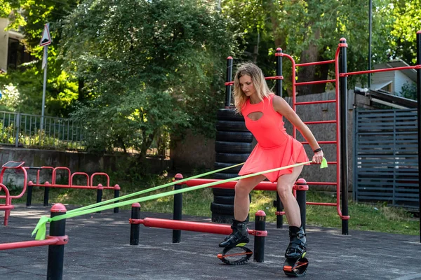 Pretty Slim Woman Kangoo Jumps Doing Exercising Street Simulators Healthy — Fotografia de Stock