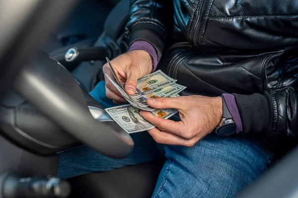 車内で新しいドル札を持っている男性の車の運転手の手 事業概念 — ストック写真