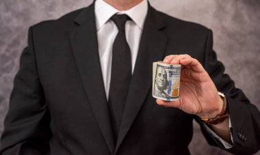 a high-ranking official in an elegant expensive suit puts the looted money in his pocket. Bribery concept