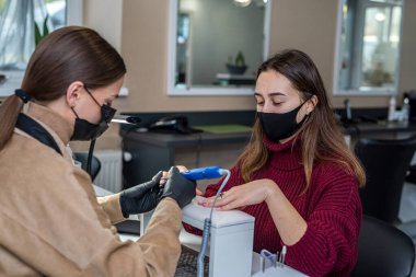 Yeni bir müşteri karantina sırasında yeni bir manikür yapmak için kalifiye bir tırnak sanatçısına geldi. Karantina sırasında güzellik salonu konsepti