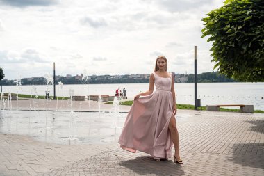 Fantezi büyüleyici kadın zarif bir gece elbisesi içinde göl kenarında dinleniyor, yaz zamanı