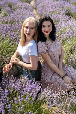 Happy friends posing together with lavender flowers on a big field