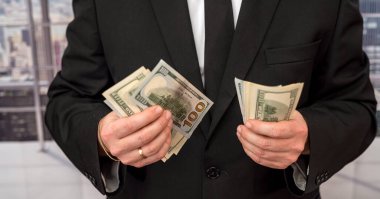 a large-scale entrepreneur calculates a salary in dollars and distributes it to workers. Salary concept in dollars