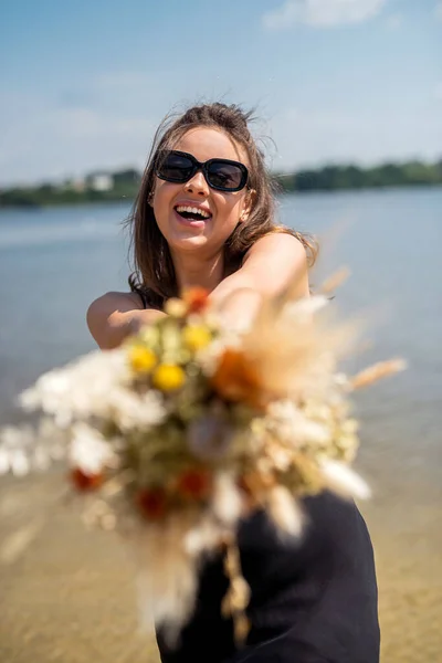 Charming Young Lady Black Dress Sunglasses Holding Bouquet Flowers Enjoys — Stock Fotó