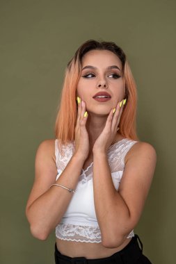 beautiful young girl stylishly dressed beautifully posing on a green background in the studio. Girl concept on background