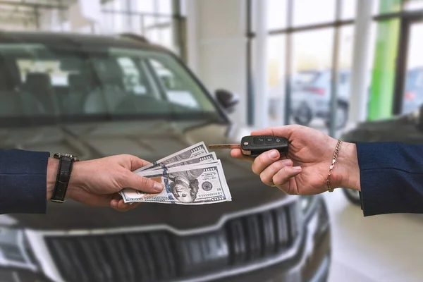 the buyer pays a large sum of dollars for the purchase of a car in one of the city's showrooms. The concept of a new grand purchase