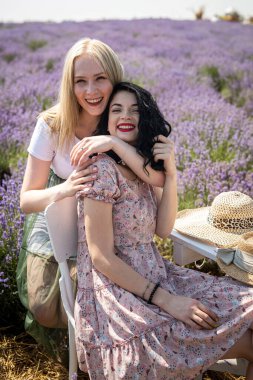 Happy and smiling friends in sunlight at lavender field