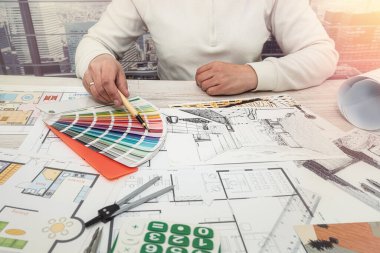 Art designer man chooses colors for office work. The choice of colors in the drawing of the apartment.