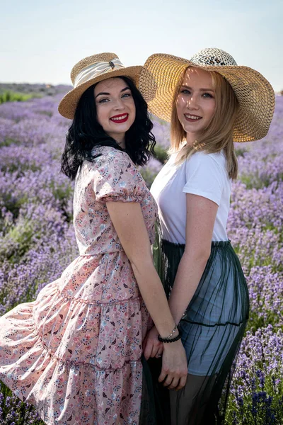 Happy friends posing together with lavender flowers on a big field
