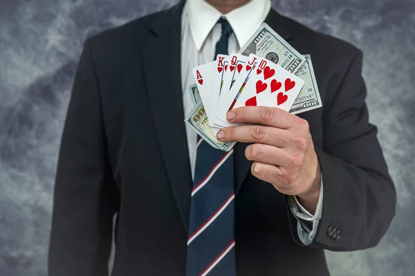 man in suit holding play card with us dollar bills. poker game