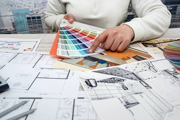 Art designer man chooses colors for office work. The choice of colors in the drawing of the apartment.