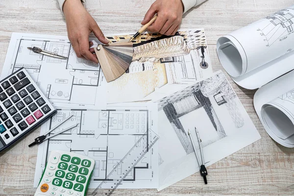 a professional architect makes a custom sketch of an apartment building in a large complex. Male hands draw sketches of drawings at the table