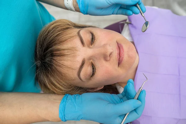 Μια Γυναίκα Οδοντίατρος Και Βοηθός Της Ειδικά Ρούχα Εξετάζουν Δόντια — Φωτογραφία Αρχείου