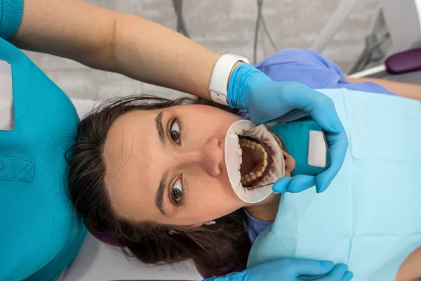 The orthodontist uses an intraoral scanner to scan the patient's teeth. The concept of a modern dental clinic with treatment.