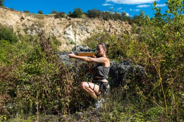 Açık havada poz veren seksi avcı, yaz zamanı.