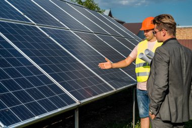 Proje yöneticisi, güneş panelinin çalışan kurulum süreci ile görüşür