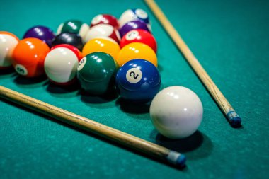 Siyah elbiseli güzel kadın ellerini elinde bir ıstaka tutarken ve bilardo katmanını deliğe sokmaya çalışırken görebilirsiniz. Bilardo sporu oyun konsepti