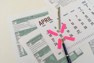 tax forms and next to the calendar with a date mark when you need to file a return. The concept of an important date for taxpayers